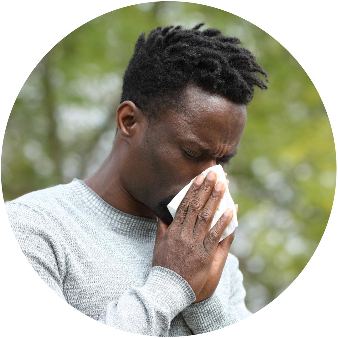A man blowing his nose because of allergy
